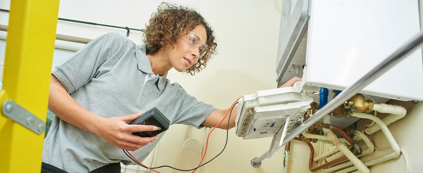 tradesperson fixing a boiler banner