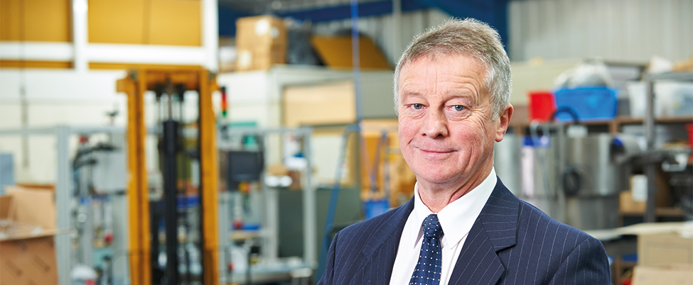 Suited gray haired businessman in warehouse