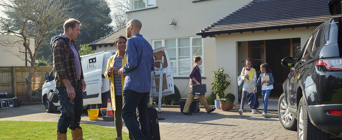 Tradesman and couple outside home