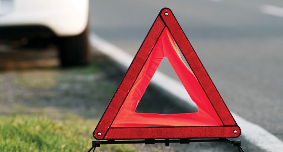 Hazard triangle with white hatchback in background