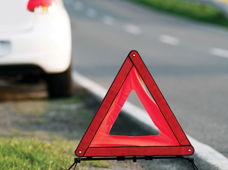 Hazard triangle with white hatchback in background