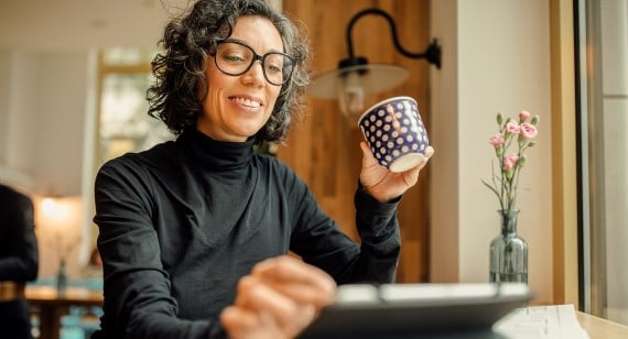 Lady using tablet while drinking tea